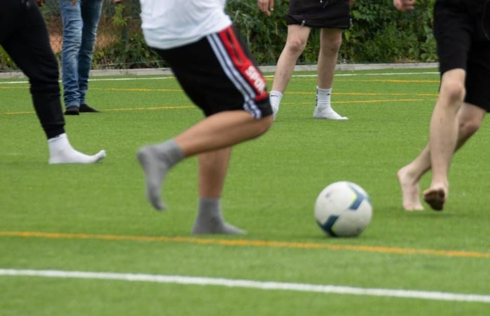 Copii jucand fotbal desculti
